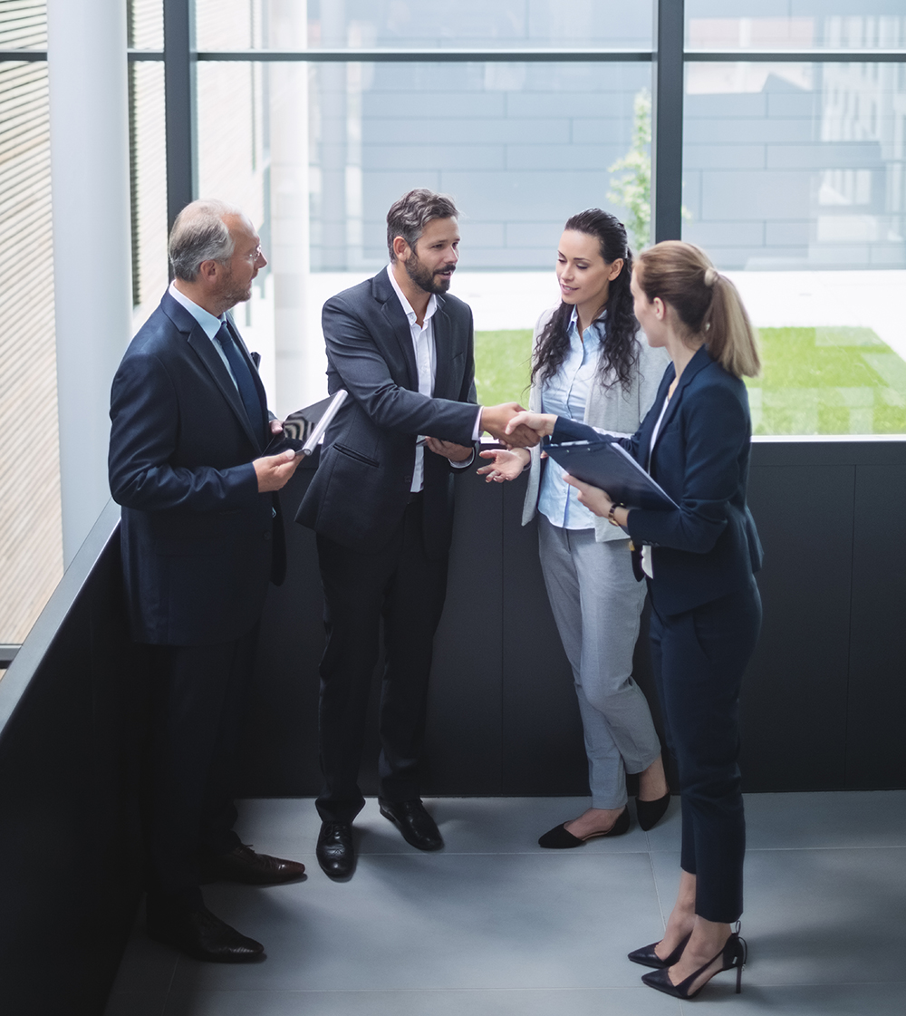 Group of businesspeople having a discussion near staircase in office